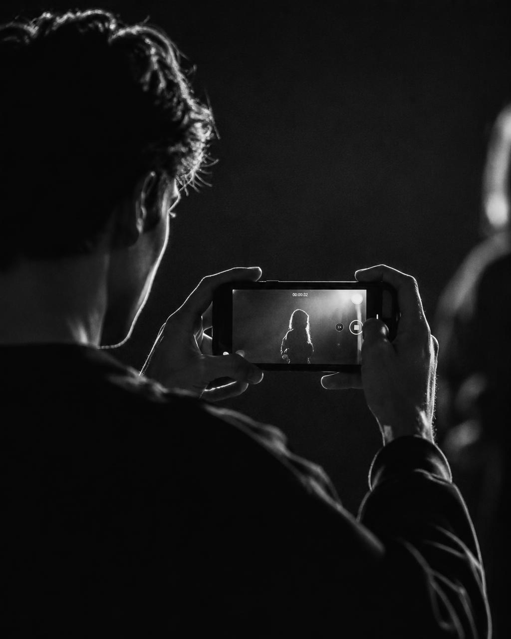 Pessoa gravando vídeo com smartphone em estúdio
